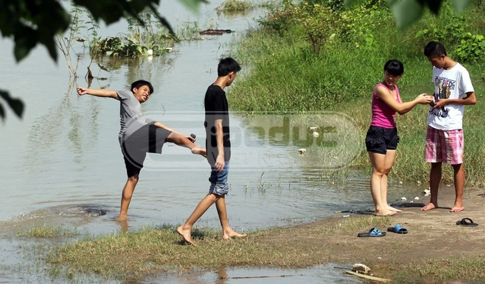 Tránh nóng ở nhà, nhiều bạn trẻ đổ xô ra bãi đá sông Hồng đang mùa nước lên để xả cái oi nồng những ngày qua.